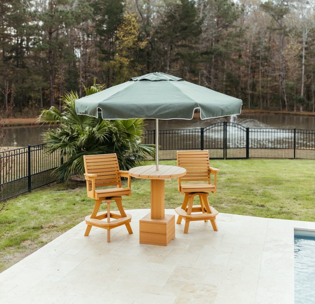 All-weather outdoor furniture with poly lumber table and Sunbrella umbrella canopy.