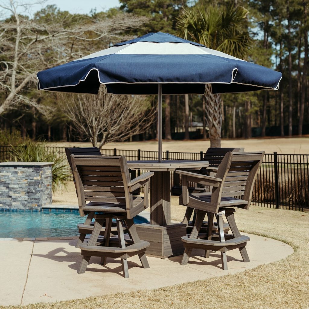 Outdoor dining furniture and umbrella beside a residential swimming pool