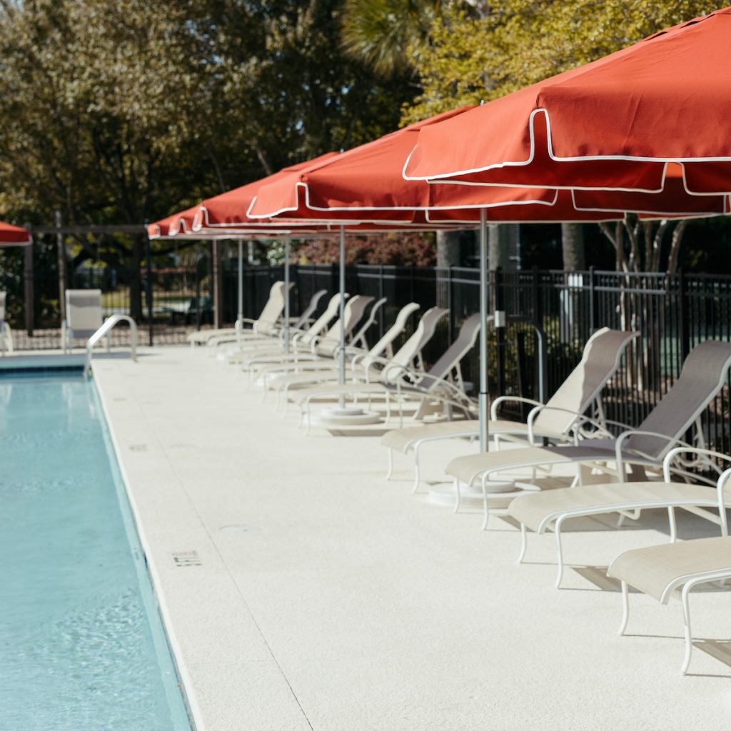 Commercial outdoor umbrellas and side tables for a residential community pool