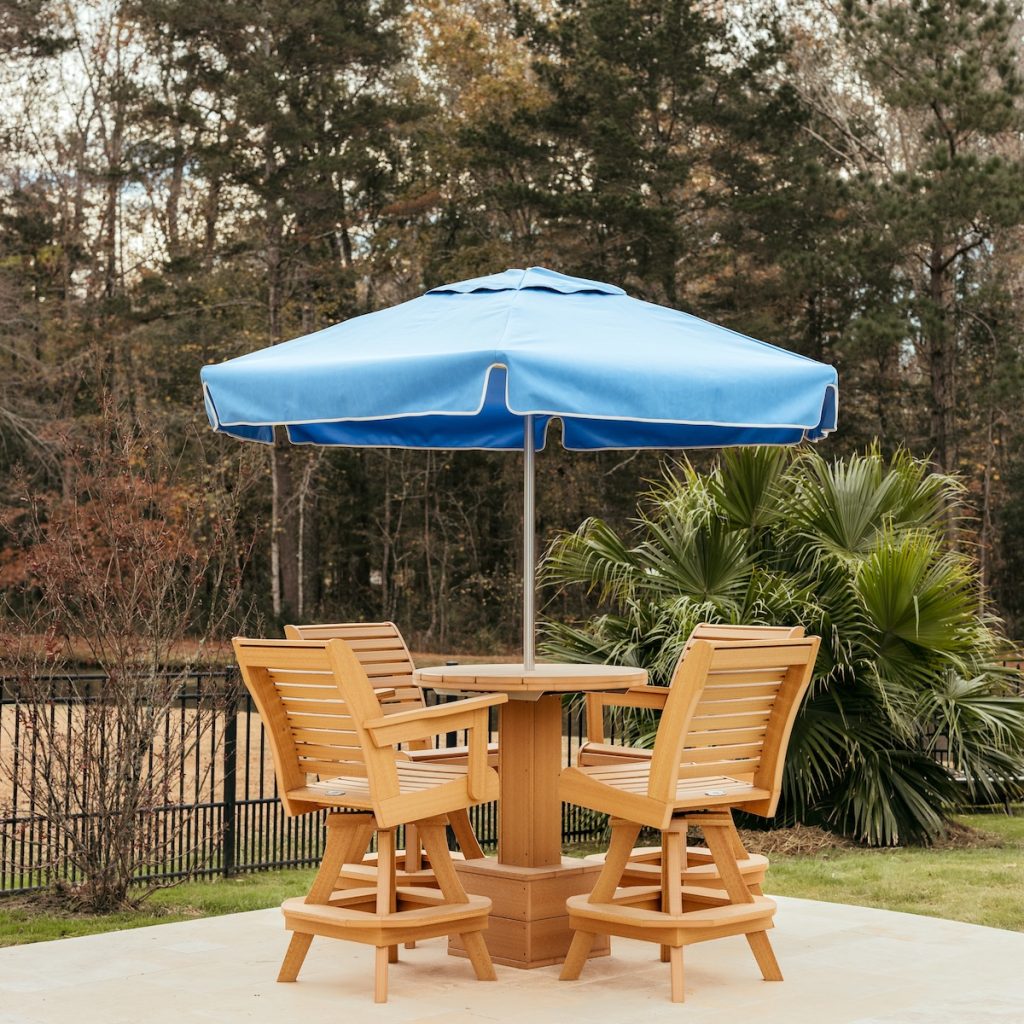 Palmetto Collection outdoor dining furniture with umbrella, dining table, and chairs on a backyard patio.